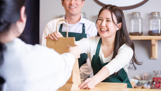笑顔で商品を受け渡す様子