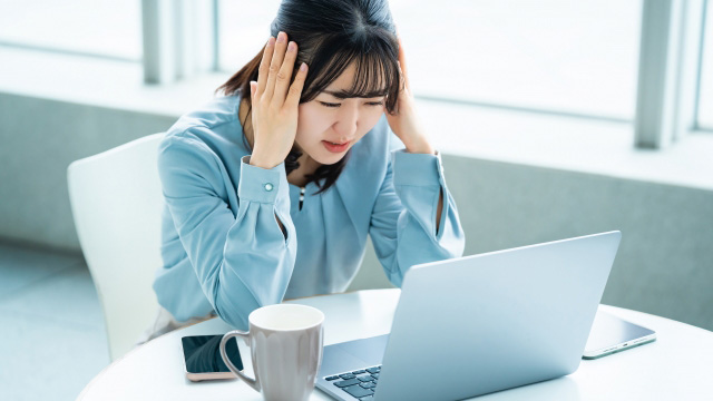 商品が売れず頭を抱えて悩む女性