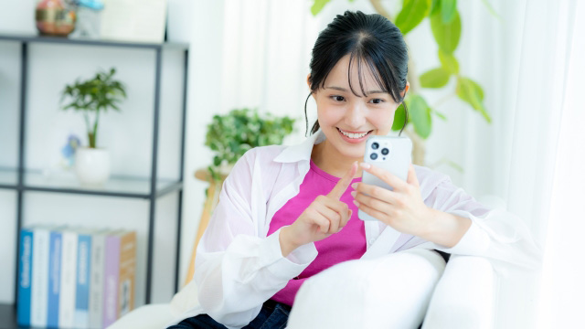 スマホで楽し気にネットショッピングをする女性